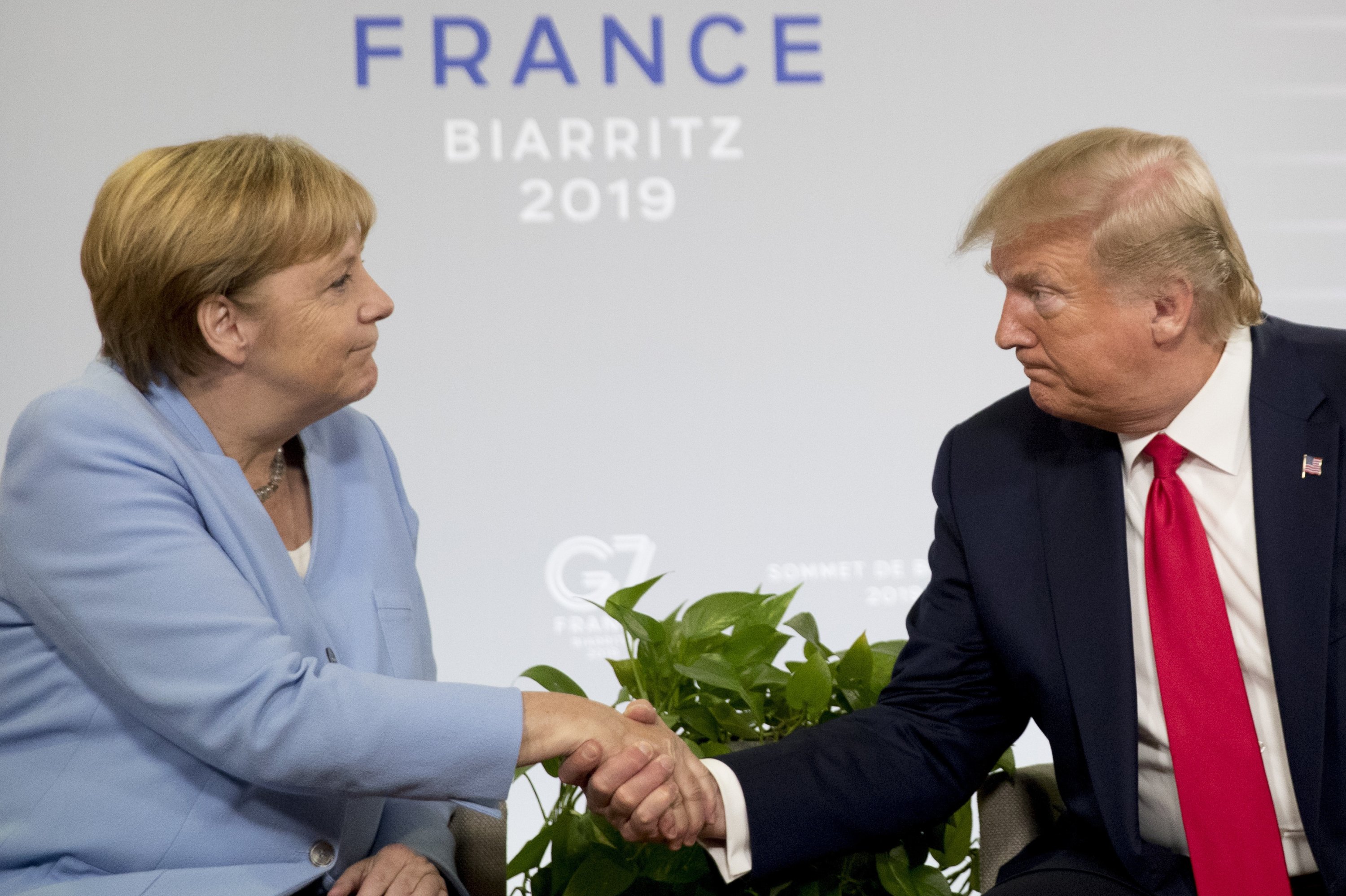 Президент США Дональд Трамп (R) та канцлер Німеччини Ангела Меркель потискують руку під час двосторонньої зустрічі на саміті 