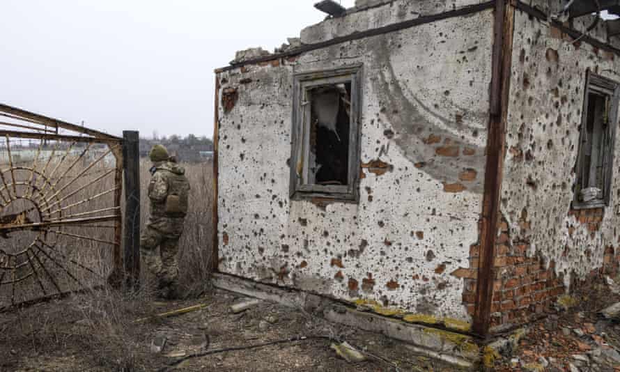 Український військовий проходить повз покинутий будинок на передовій.