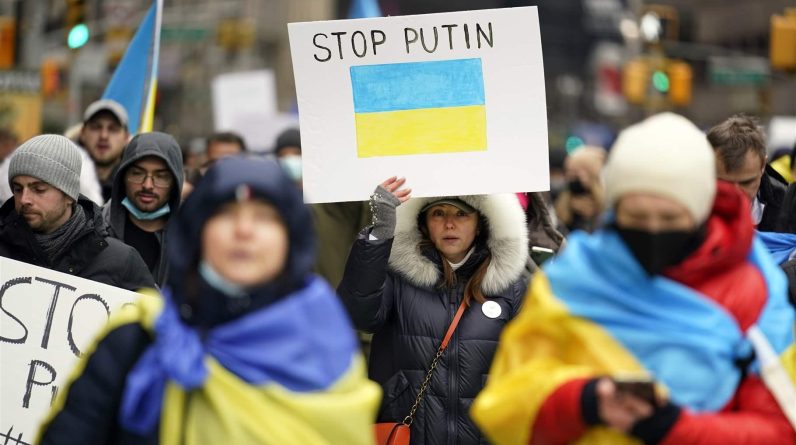Pro-Ukraine demonstrators carrying signs as they march in New York City.