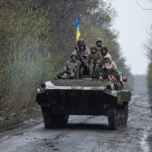Ukrainian servicemen ride atop an armoured fighting vehicle, as Russia