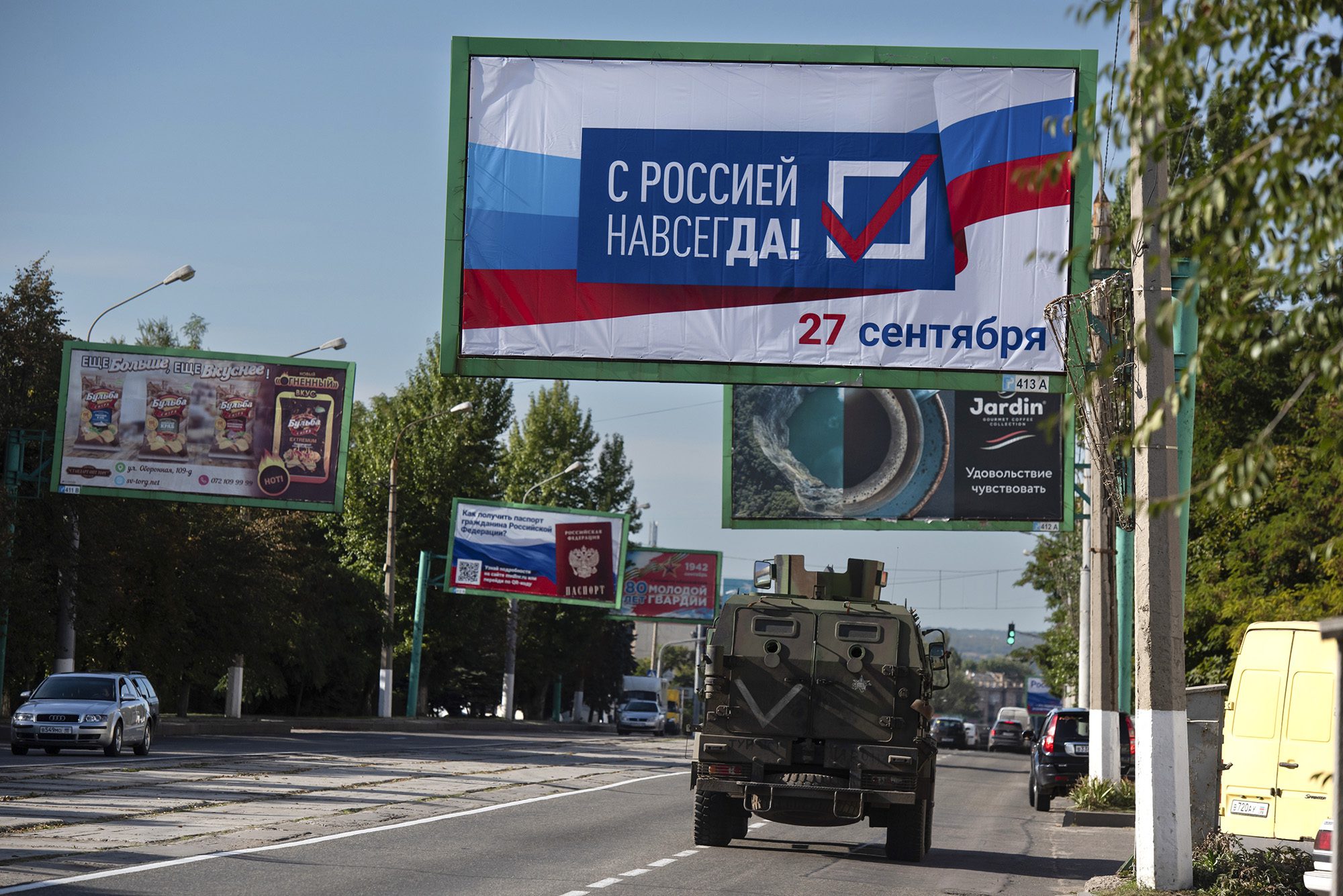 Військова машина біжить по вулиці з рекламним щитом "З Росією назавжди 27 вересня" Перед референдумом у Луганську, східна Україна, 22 вересня.